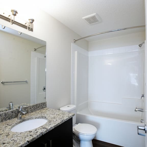 a white bathroom with a sink, toilet, and bathtub.