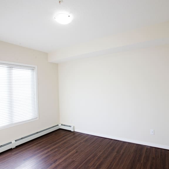 a room with a window and wooden floors.