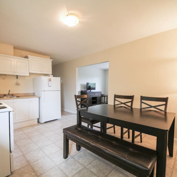 a kitchen with a white refrigerator and a black table.