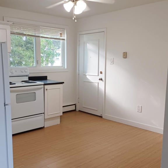 a kitchen with white appliances and a white door.