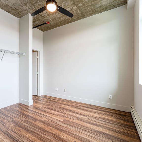 a room with a wooden floor and a ceiling fan.