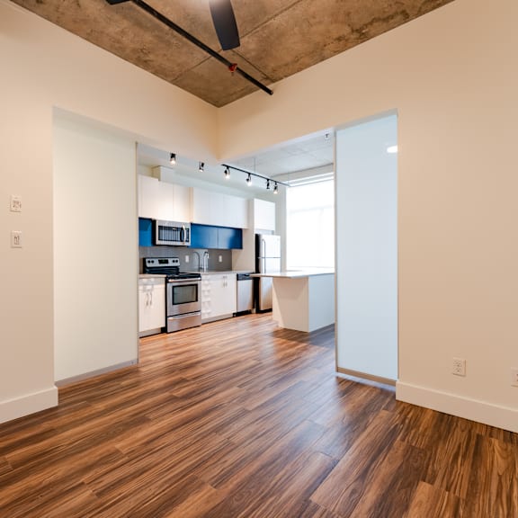 a kitchen with white cabinets and a wooden floor.