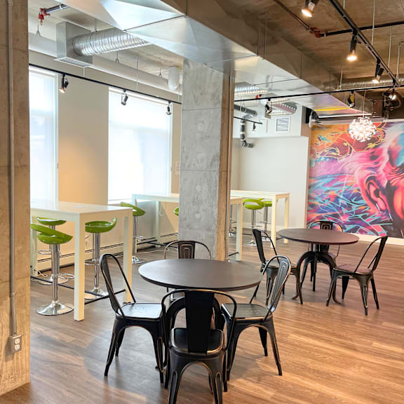 a modern dining area with a large mural on the wall.