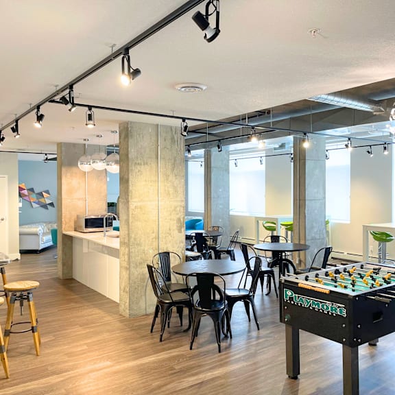 a room with a pool table and a bar area.