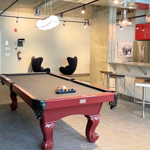 a pool table in a room with a red cloth and balls on it.