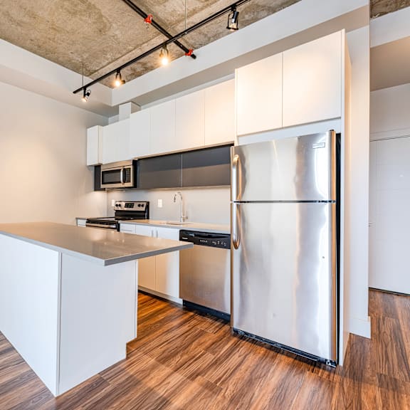 a kitchen with a refrigerator, microwave, and oven.