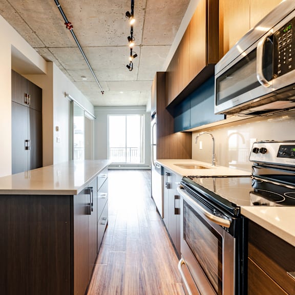 a modern kitchen with dark wood cabinets and stainless steel appliances.