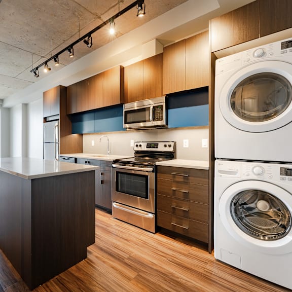 a modern kitchen with a washing machine and dryer built into the cabinetry.