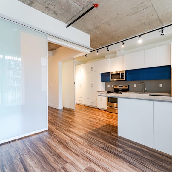 a kitchen with white cabinets and a blue accent wall.