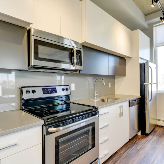 a modern kitchen with a stove, oven, microwave, and refrigerator.