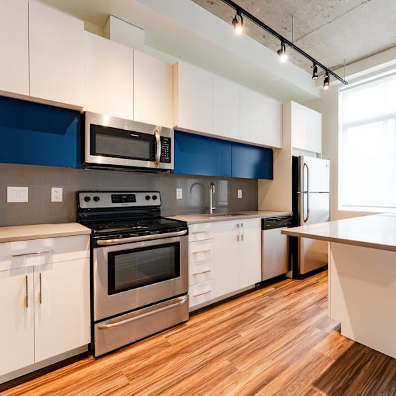 a modern kitchen with a stove, oven, microwave, and refrigerator.