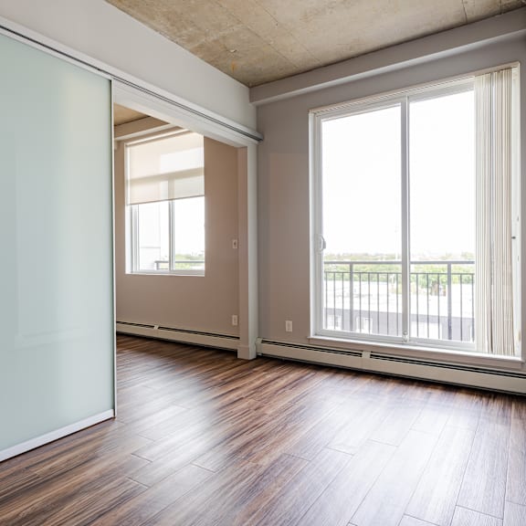 a room with a sliding glass door and wooden flooring.