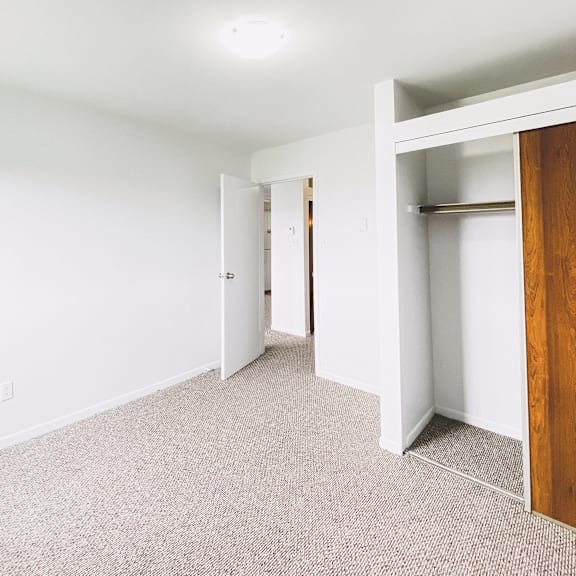 a room with a carpeted floor and a wooden door.