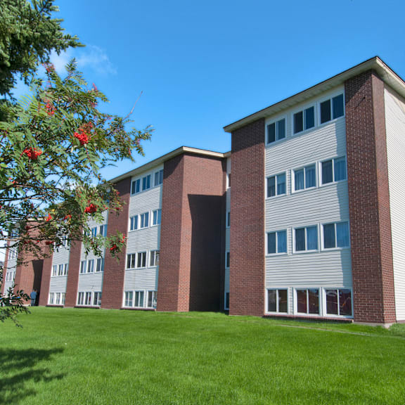 a red and white building with a green lawn in front.