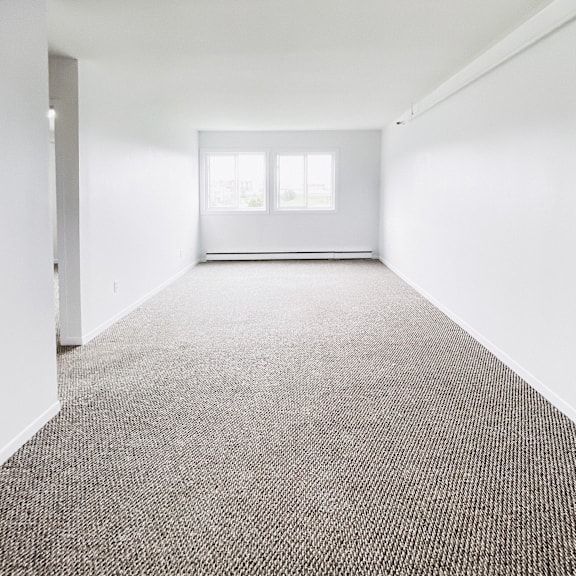 a room with a carpeted floor and a window.