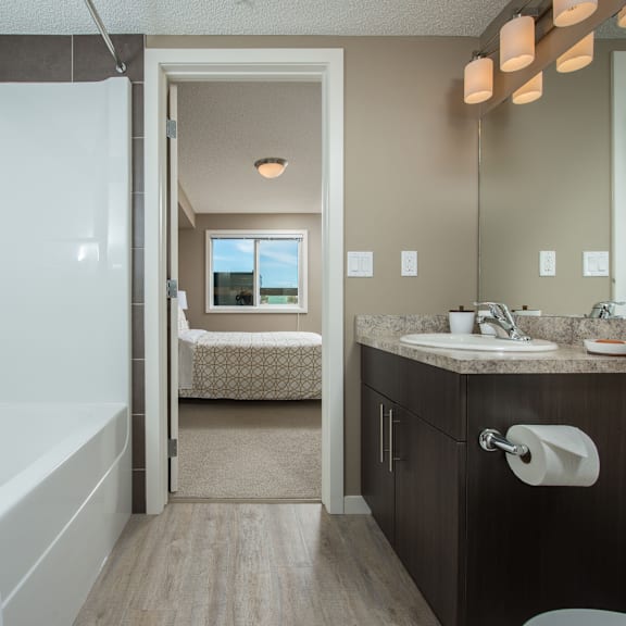a bathroom with a white shower stall, a sink, and a toilet.
