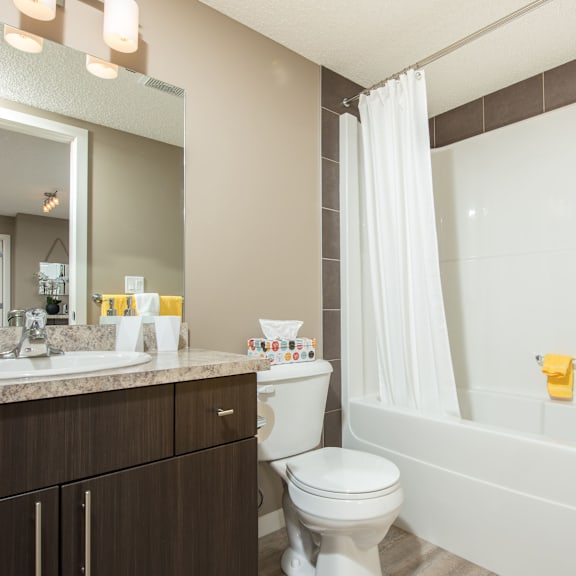 a bathroom with a white toilet, sink, and bathtub.