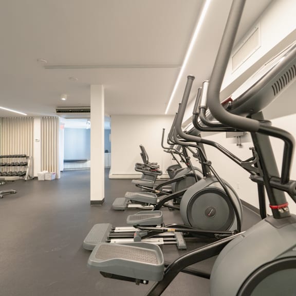 a gym with treadmills and elliptical machines.