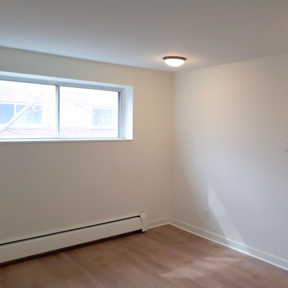 a room with a window and a white wall.