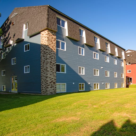 a large building with a mix of blue and grey siding.