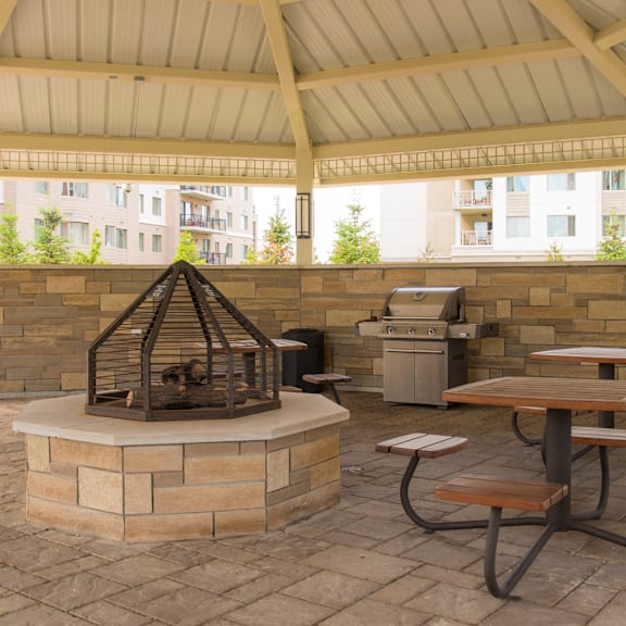 a patio with a fire pit and picnic table.