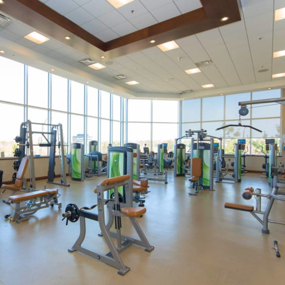 a gym with a variety of equipment including weights and machines.