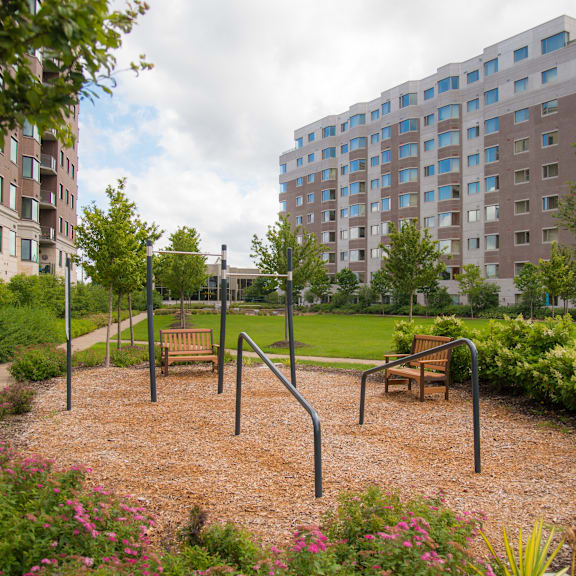 a playground with a swing set and a slide in front of a large apartment building.