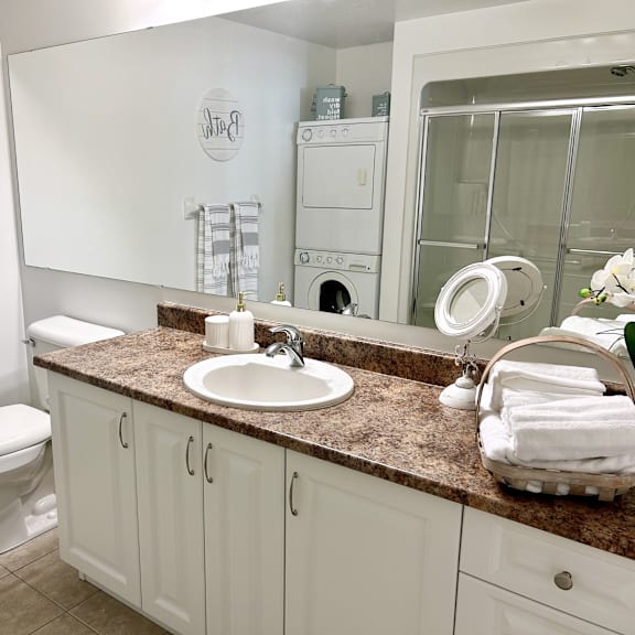 a bathroom with a toilet, sink, and mirror.