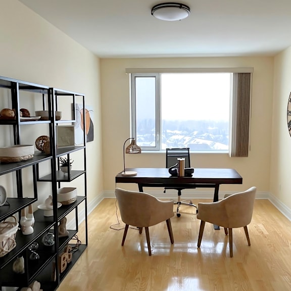 a room with a table, chairs and a shelf with objects on it.