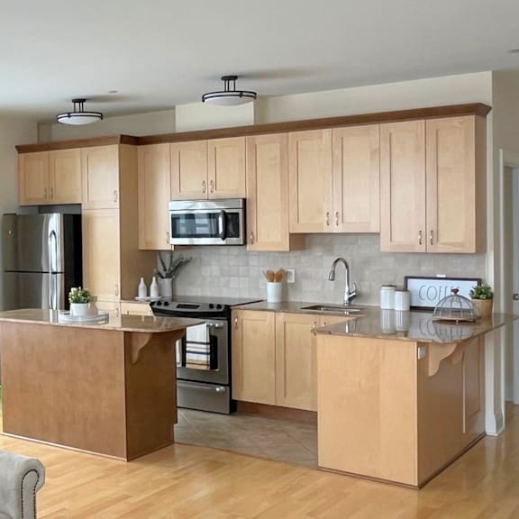 a modern kitchen with wooden cabinets and stainless steel appliances.