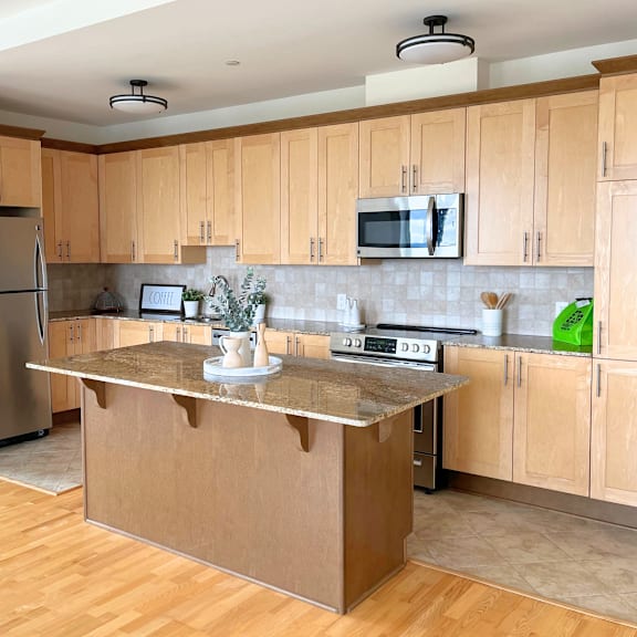 a kitchen with wooden cabinets and a stainless steel refrigerator.