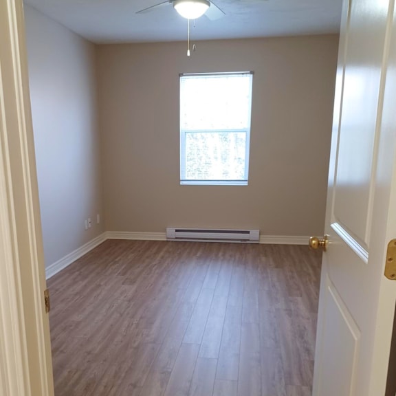 a room with a window and a ceiling fan.