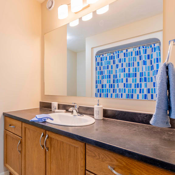 a bathroom with a sink, mirror, and blue towel.