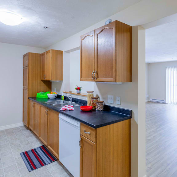 a kitchen with wooden cabinets and a black countertop.