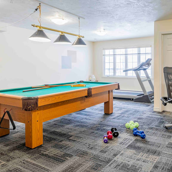 a pool table with a green felt cloth and a set of pool balls on the floor.
