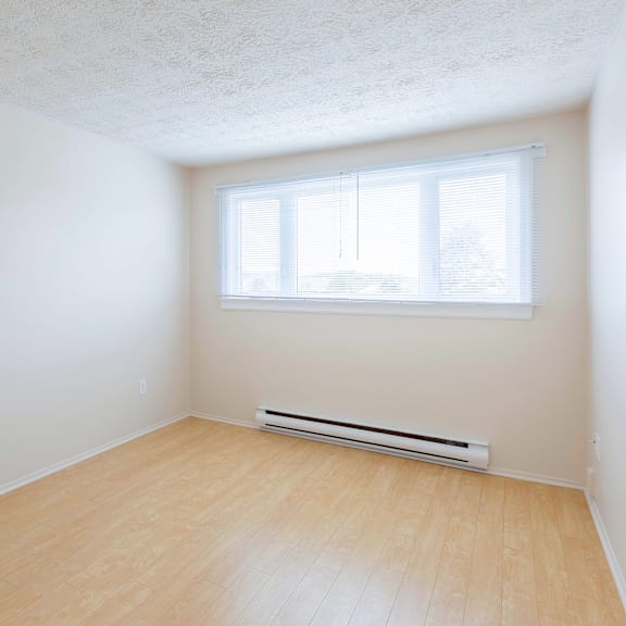 a room with a window and a radiator on the wall.