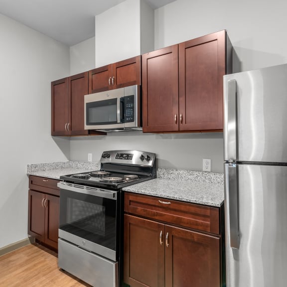 Thumbnail 3 of 7 an empty kitchen with stainless steel appliances and granite counter tops
