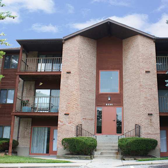 a brick apartment building with a red door and balconies  at four worlds apartments, cincinnati, 45231