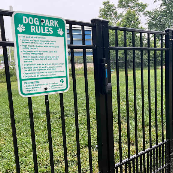a sign in a dog park outlines the rules for visiting the park.