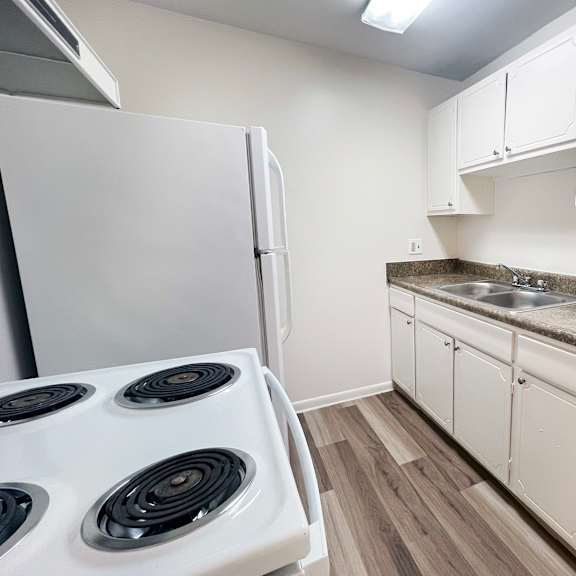 a kitchen with a white stove and cabinets.