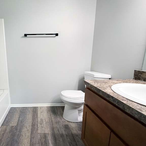 a white toilet sits in a bathroom next to a sink.