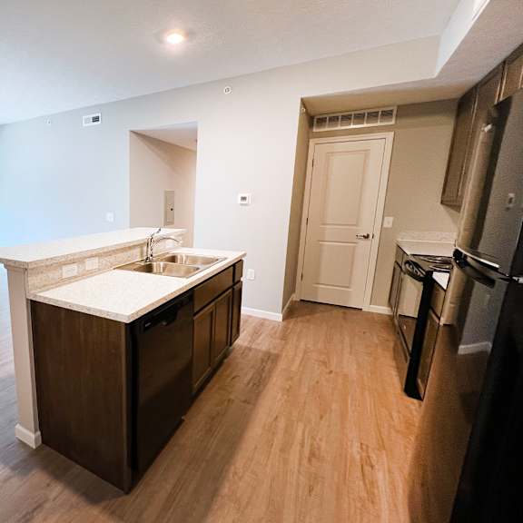 an empty kitchen and living room with wood flooring and a large window  at brookfield village apartments, ohio