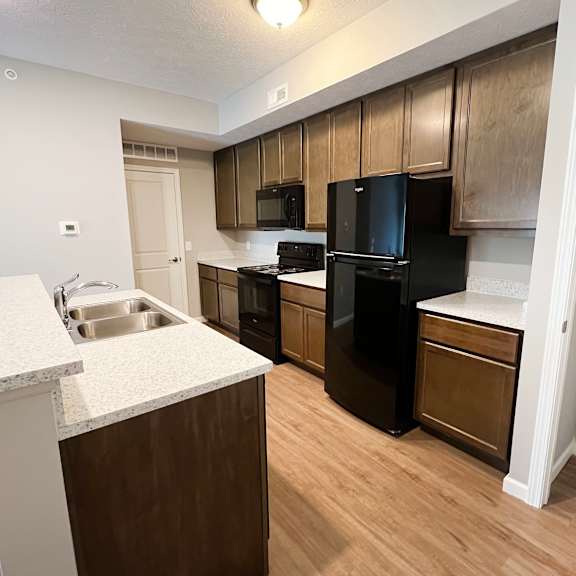 a kitchen with black appliances and wooden cabinets  at brookfield village apartments, grove city, oh, 43123
