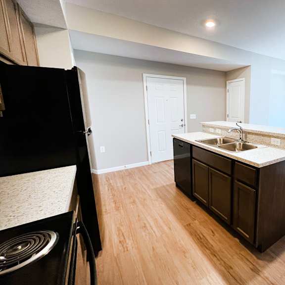an empty kitchen and living room with wood flooring and  at brookfield village apartments, ohio, 43123