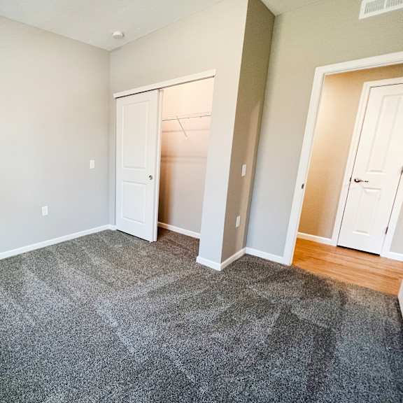 a bedroom with a carpeted floor and a closet  at brookfield village apartments, grove city