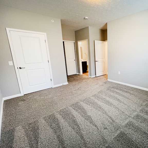 an empty living room with carpet and white doors  at brookfield village apartments, grove city, oh, 43123