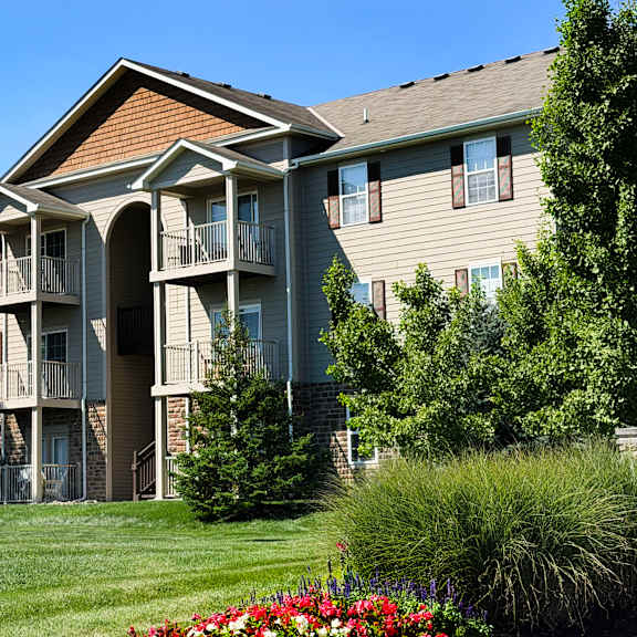 a large apartment building with a green lawn in front.