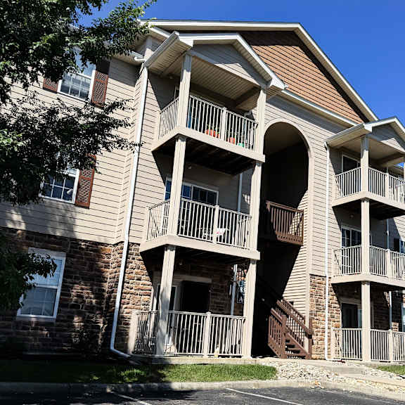 a large apartment building with a balcony on the second floor.