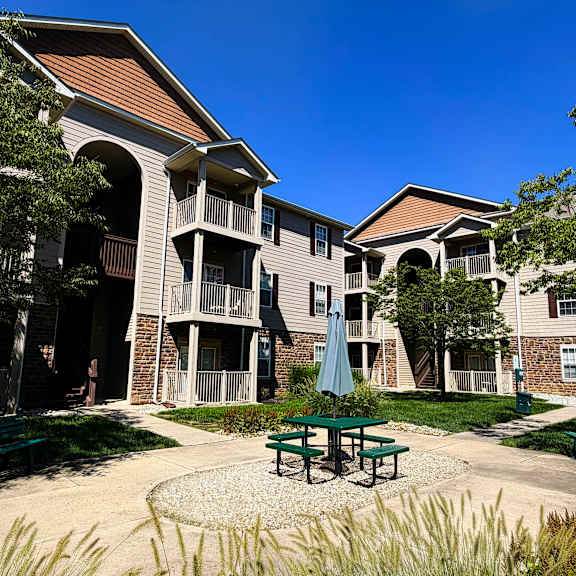 a courtyard with a table and chairs surrounded by apartment buildings.