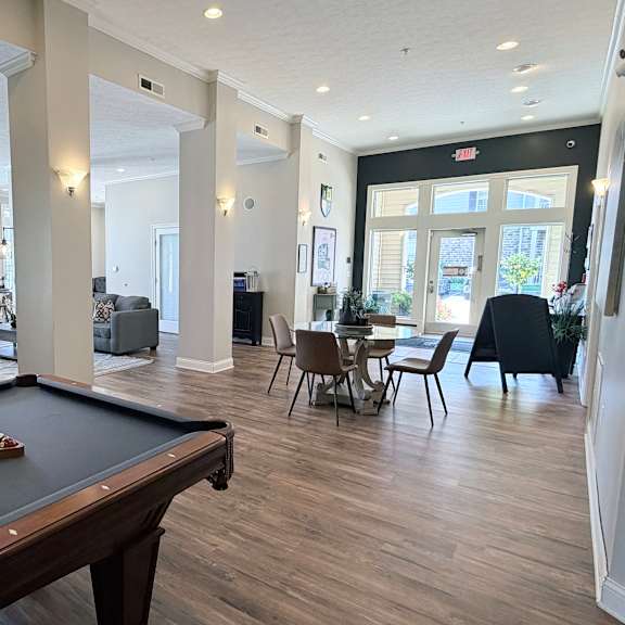 a pool table is in the middle of a room with a dining table and chairs.